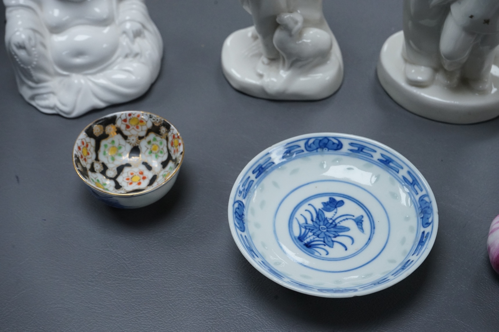 Four Chinese blanc de chine figures and two blue and white dishes and a model of a garlic bulb. Tallest figure 17.5cm.